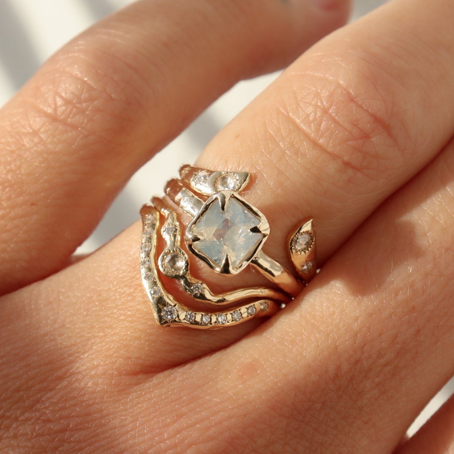 Gold ring with a large central gemstone on a person's finger