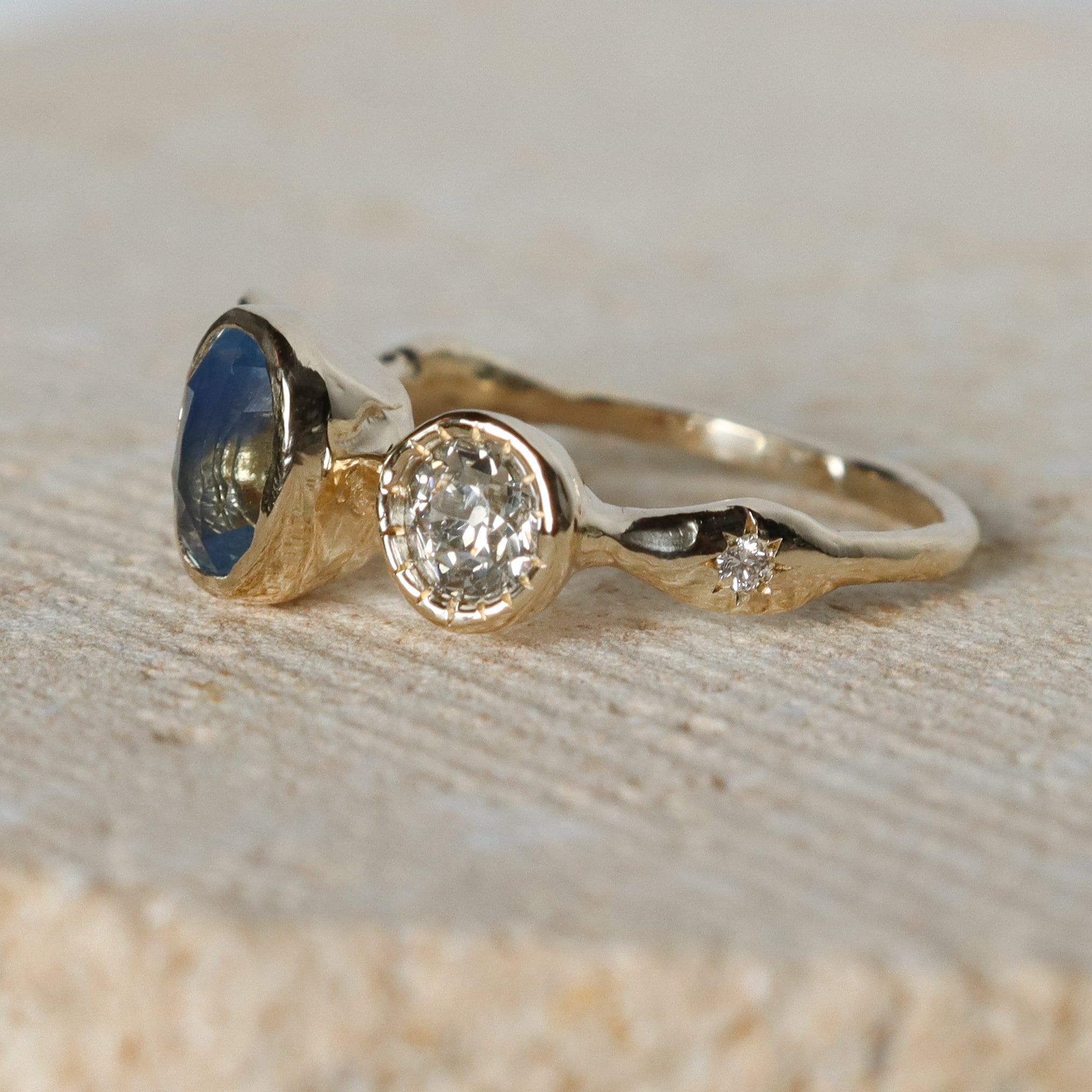 Gold ring with gemstones on a textured surface