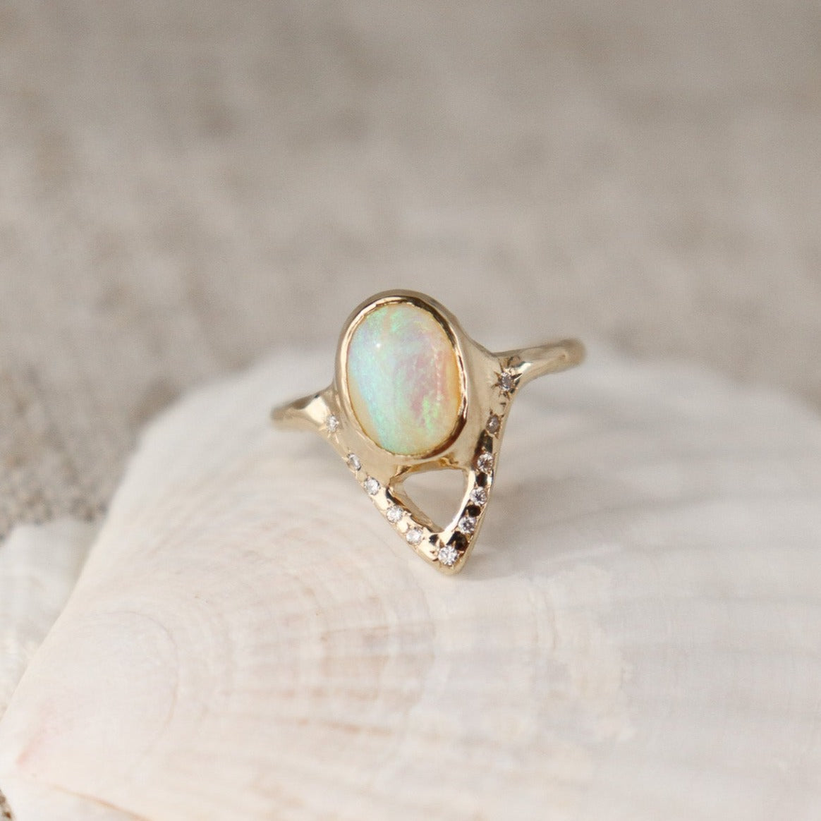 Elegant opal ring featuring a V-shaped design adorned with sparkling diamond accents.