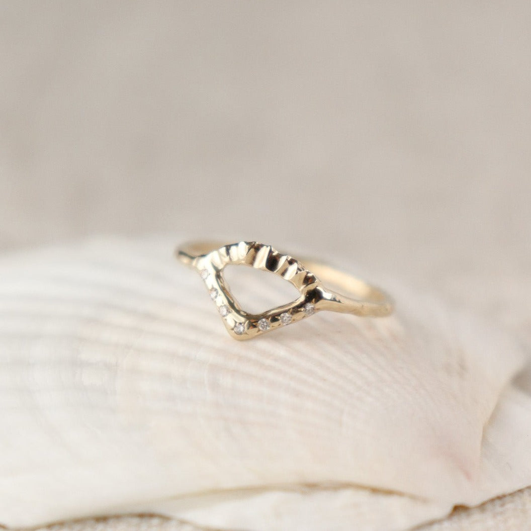 Elegant gold ring with V-shaped diamond detail and arched fin texture.