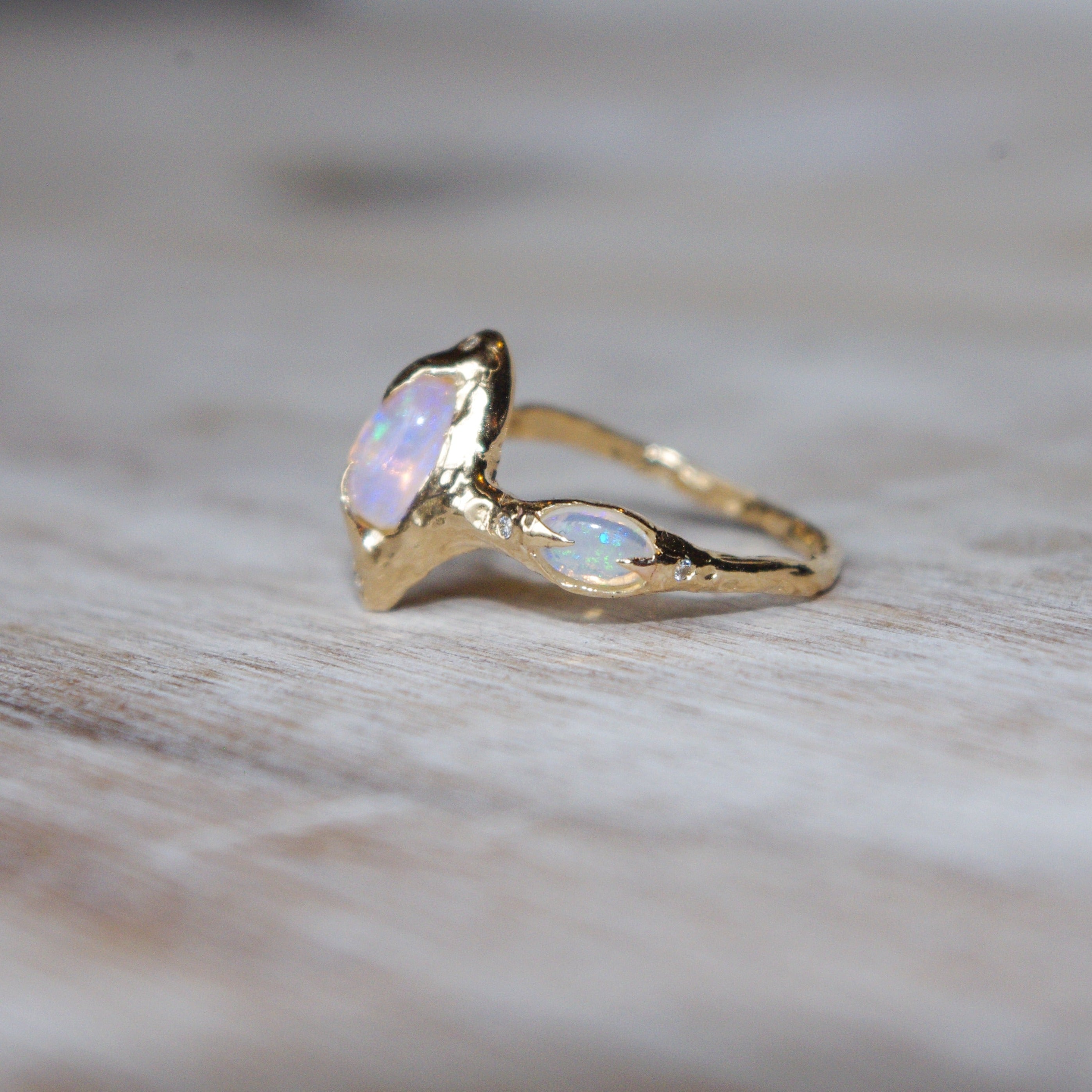 side view of a pipe opal ring showing a small oval opal set with prongs on the side of the band