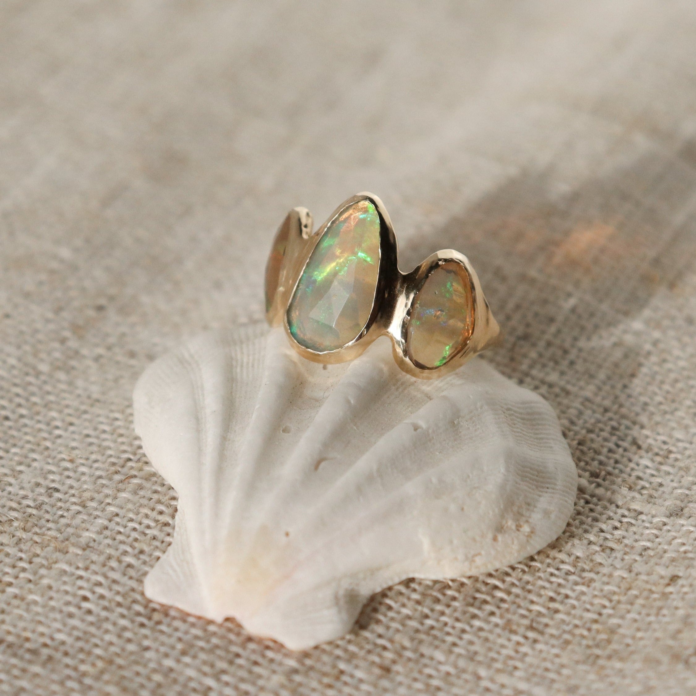 Three opals are bezel set on an organically handcrafted 14k gold band.