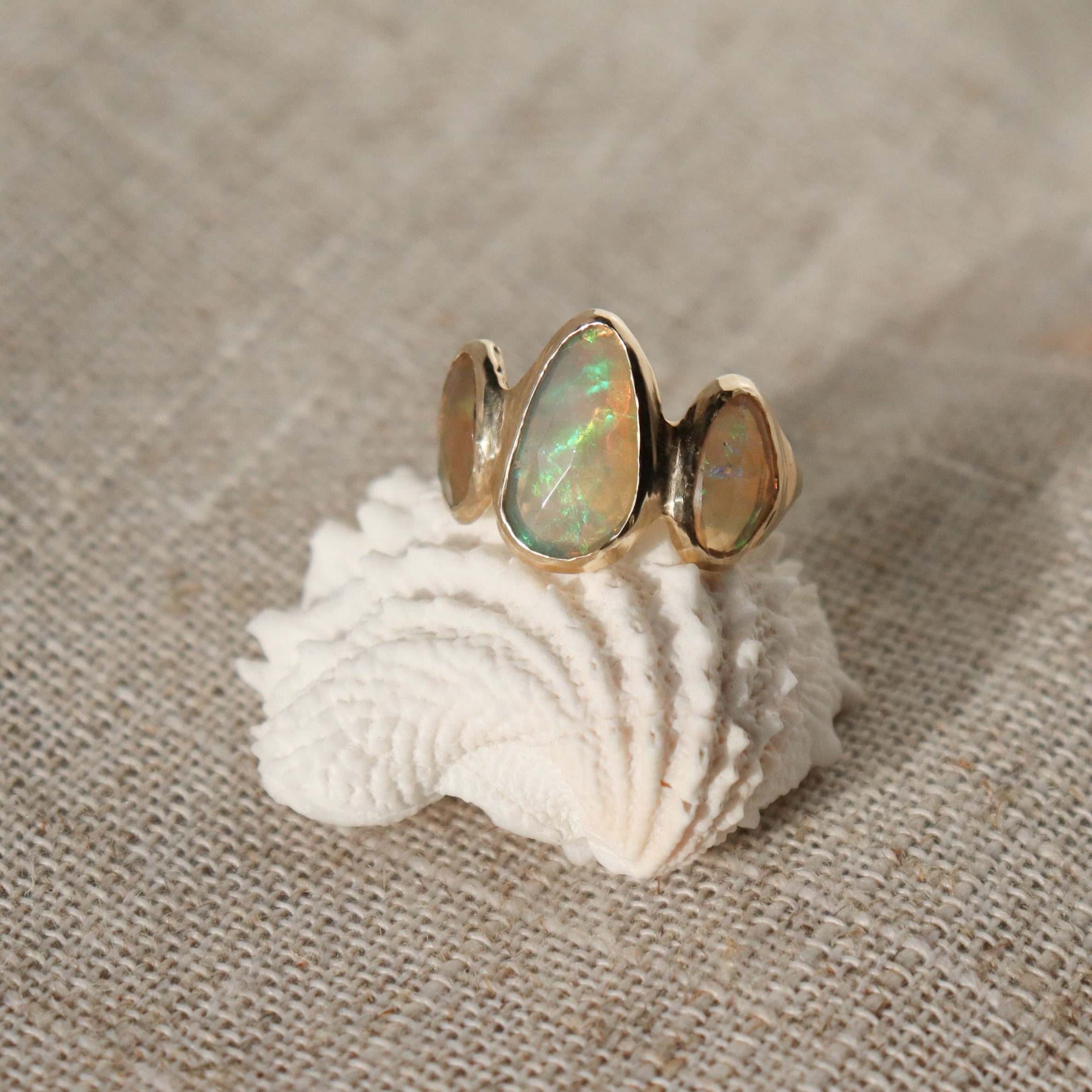 Three opals are bezel set on an organically handcrafted 14k gold band.