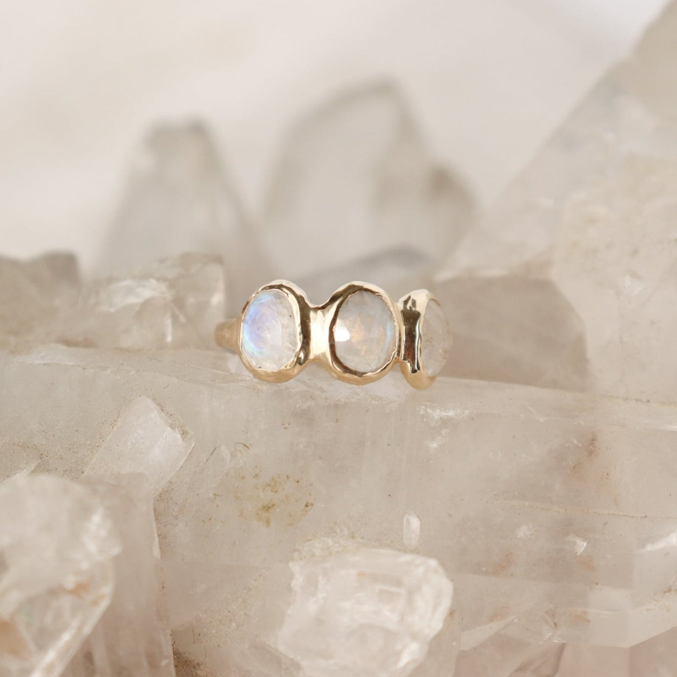Three rose cut moonstones are bezel set in 14k gold across the front of an organic band.