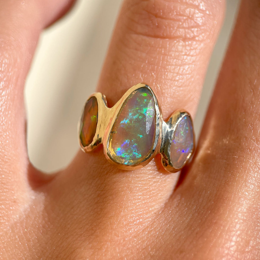 Three opals are bezel set on an organically handcrafted 14k gold band.