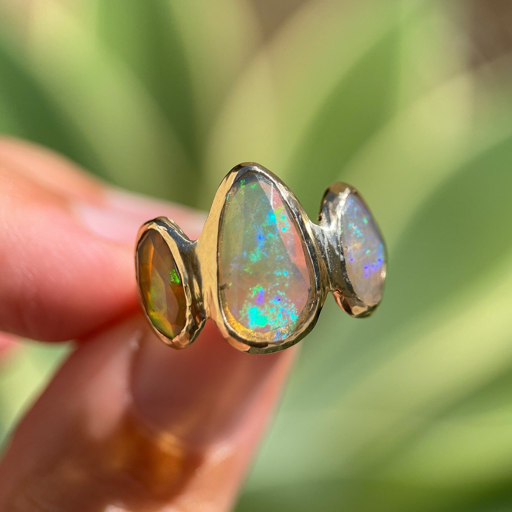 Three opals are bezel set on an organically handcrafted 14k gold band.