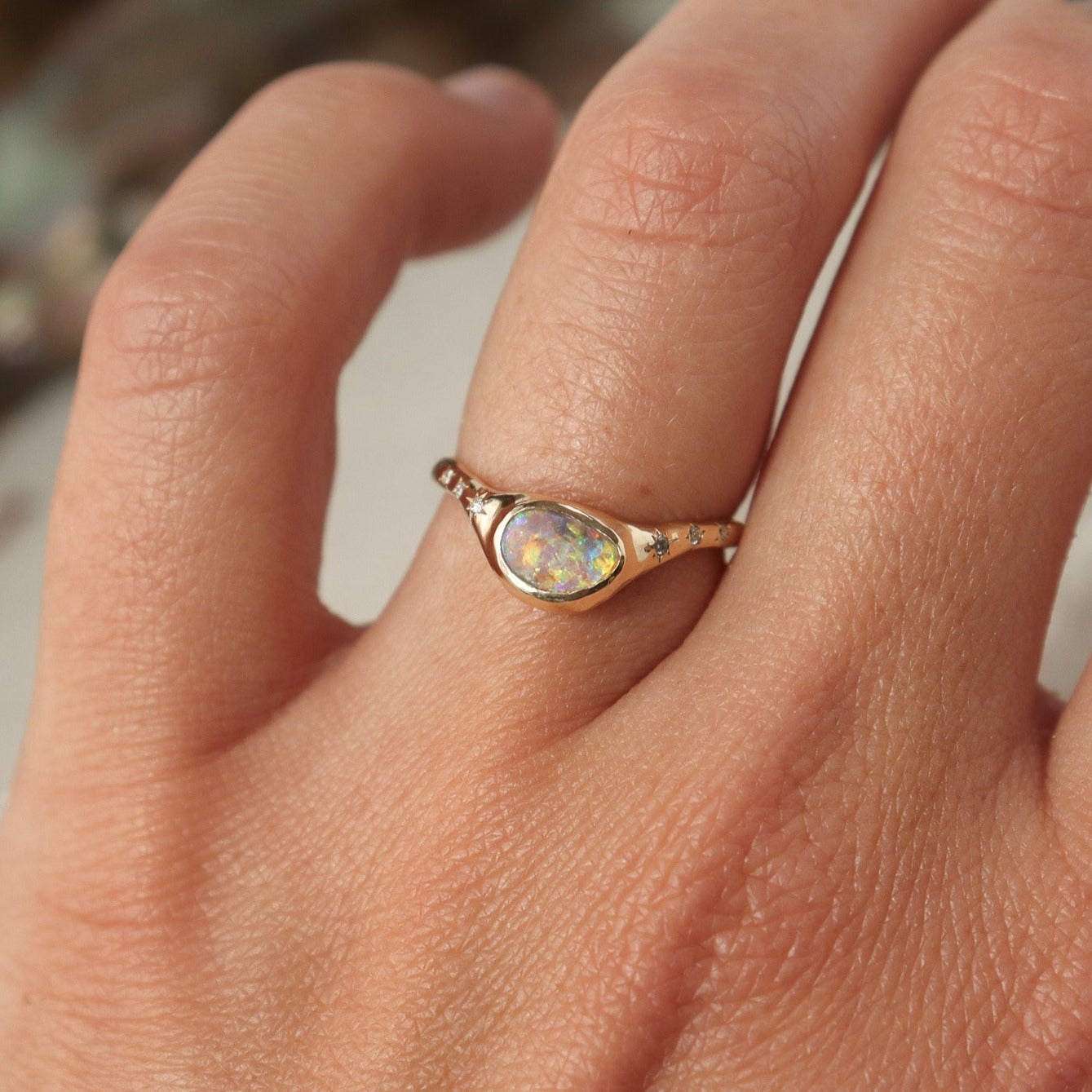 A  crystal boulder opal is bezel set on an  organically crafted band with three star set diamonds on each side of the stone.