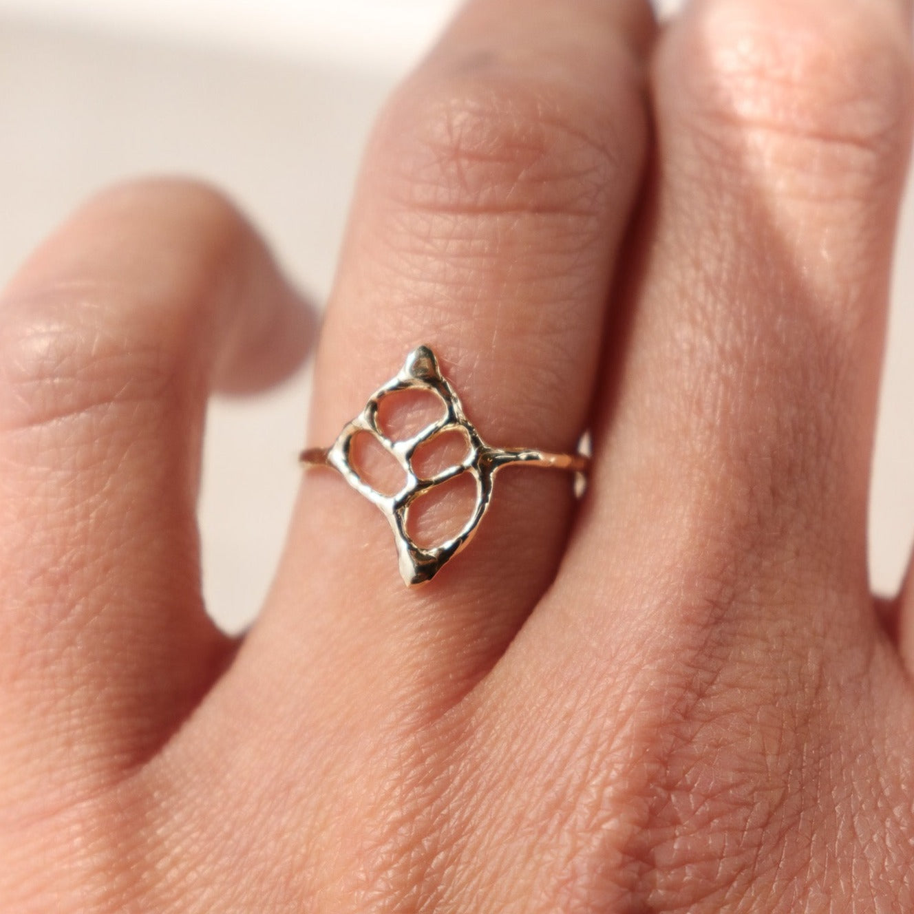 Intricate sea shell ring design resembling a split conch shell, evoking coastal beauty and natural elegance, worn to show scale.