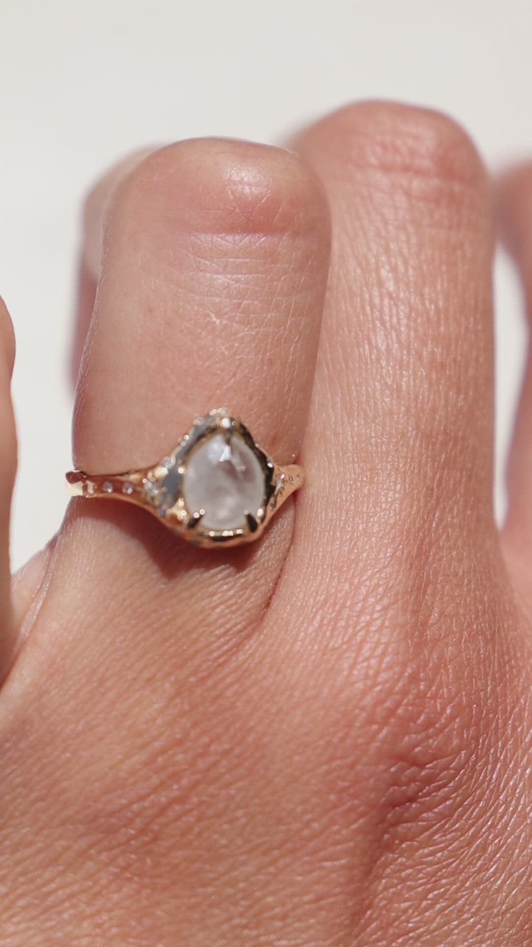 close up video of a rose cut white icy diamond ring to show all of the diamonds that surround the main stone
