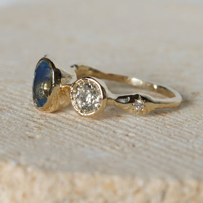 Gold ring with gemstones on a textured surface