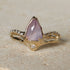 Gold ring with a pink gemstone on a stone surface