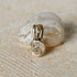 Gold pendant with a diamond on a stone surface