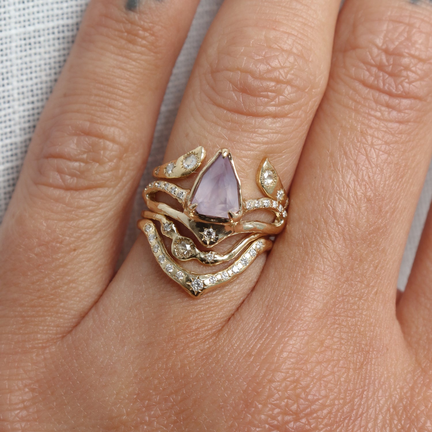 Gold rings with a purple gemstone on a person&