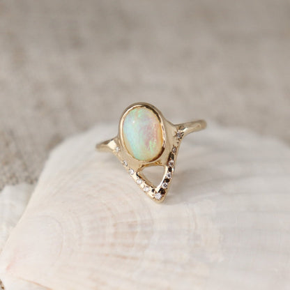 Elegant opal ring featuring a V-shaped design adorned with sparkling diamond accents.