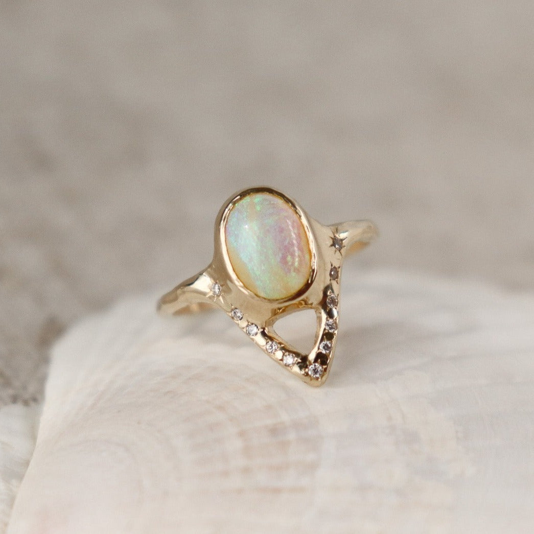 Elegant opal ring featuring a V-shaped design adorned with sparkling diamond accents