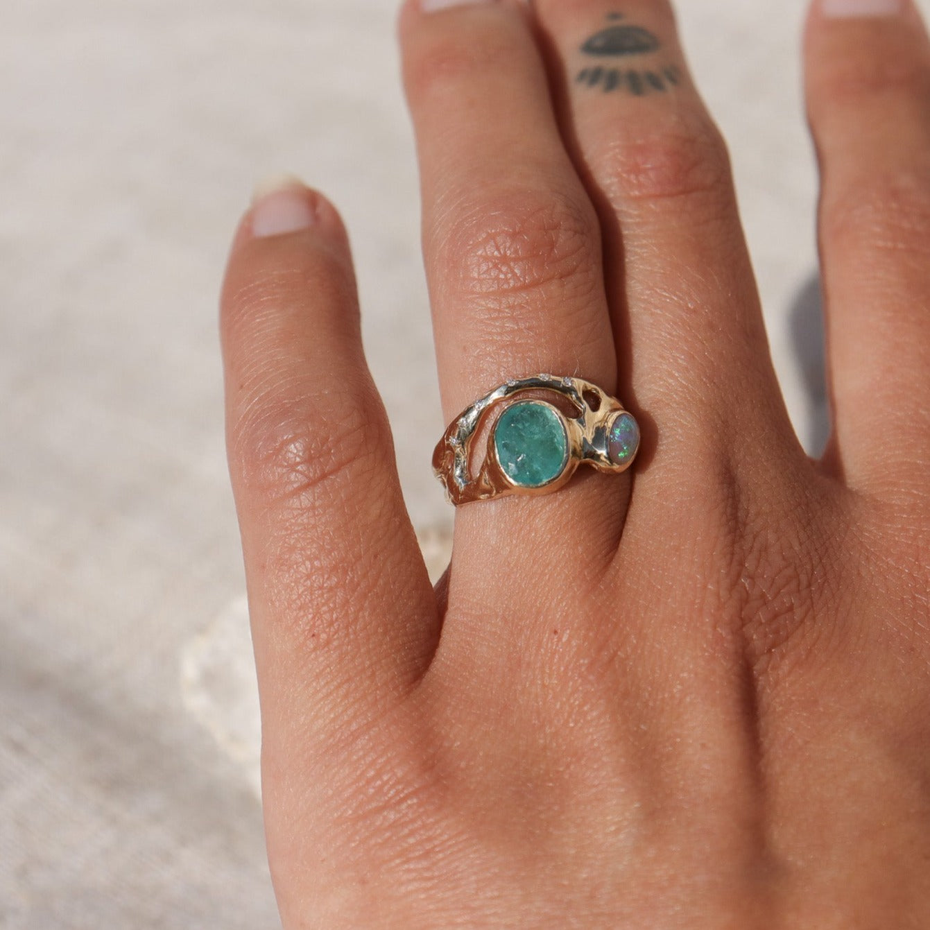 Organically shaped ring with a stunning Paraiba tourmaline and opal, bezel-set and accented with dazzling diamonds.