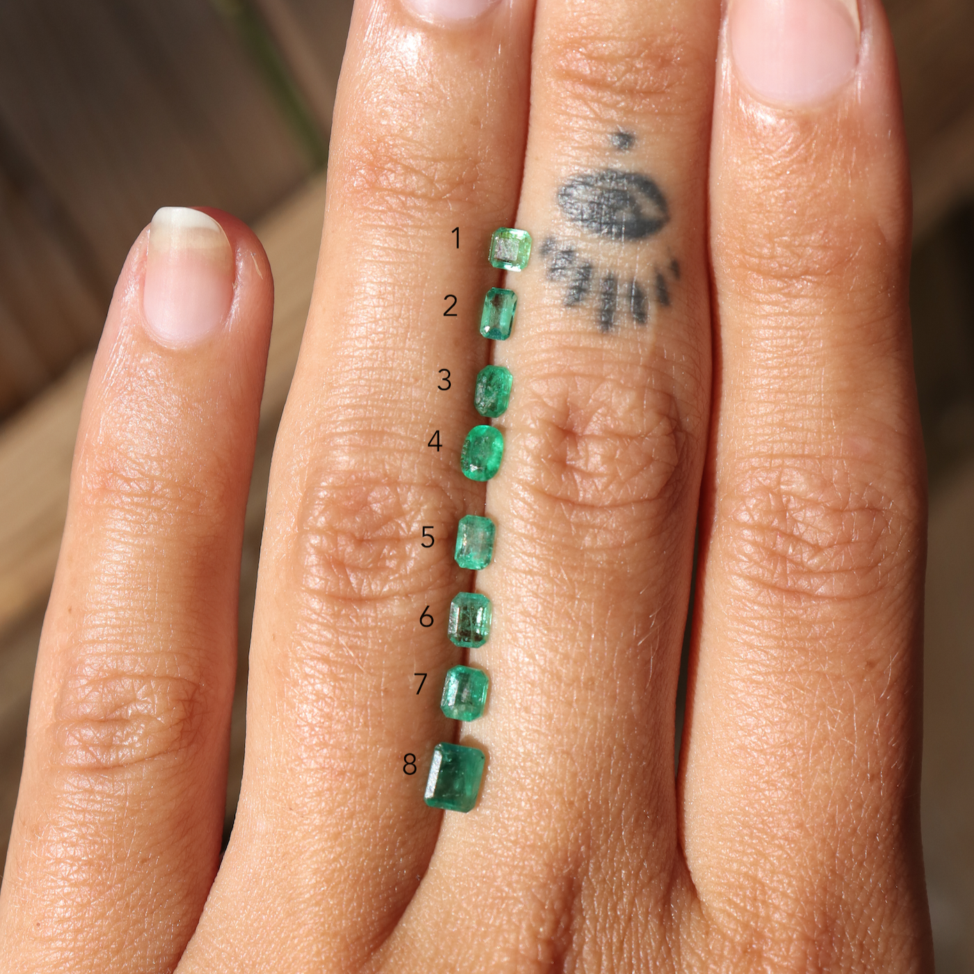 An array of emeralds with numbers to choose from when creating your own ring.