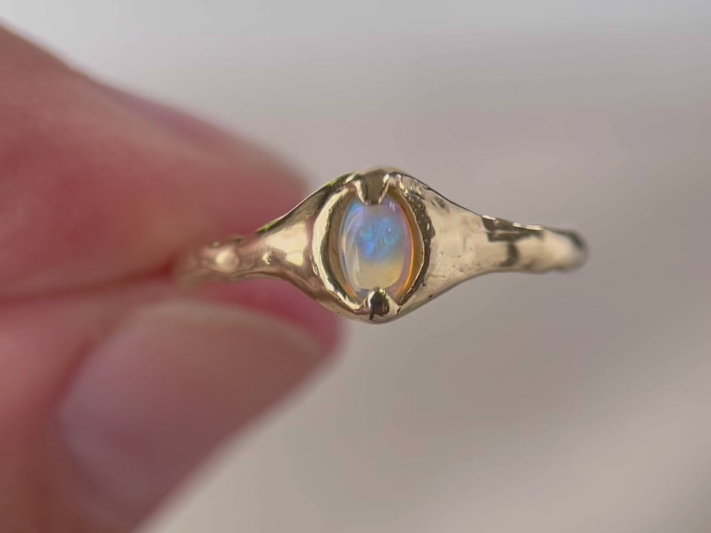 Close up video of a 14k gold opal ring.
