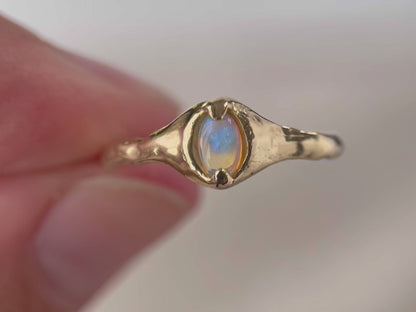 Close up video of a 14k gold opal ring.