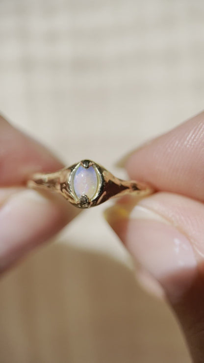 video of a close up of a gold opal ring showing the colors in the opal