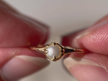 Close up video of a pearl stacking ring set in 14k gold.