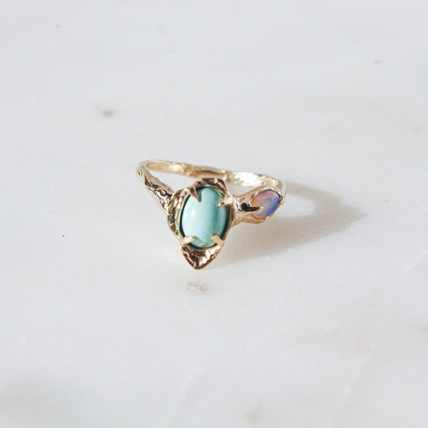 front view of a gold flower ring with variscite and opal