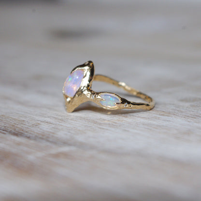 side view of a pipe opal ring showing a small oval opal set with prongs on the side of the band