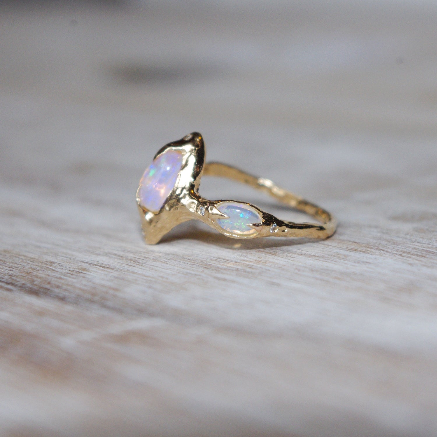 side view of a pipe opal ring showing a small oval opal set with prongs on the side of the band