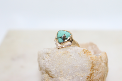 A trillion variscite is bezel set in 14k yellow gold with a v-shape band covered in pave diamonds