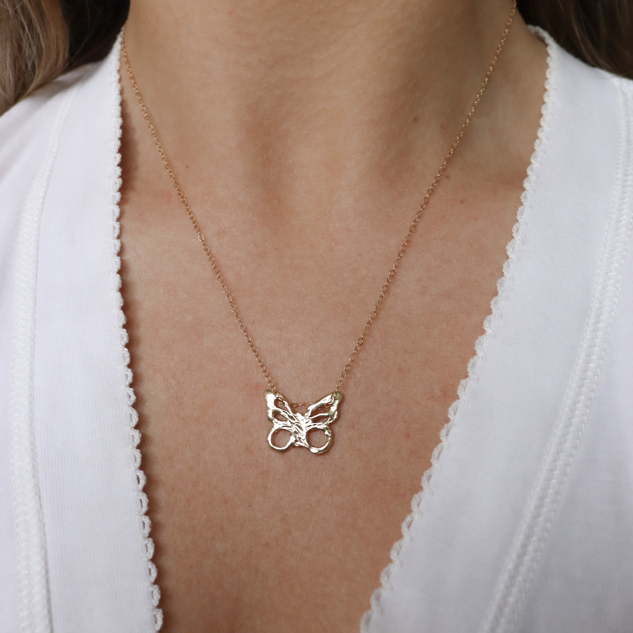 Model wears the One of a kind butterfly charm necklace made out of 14k yellow gold