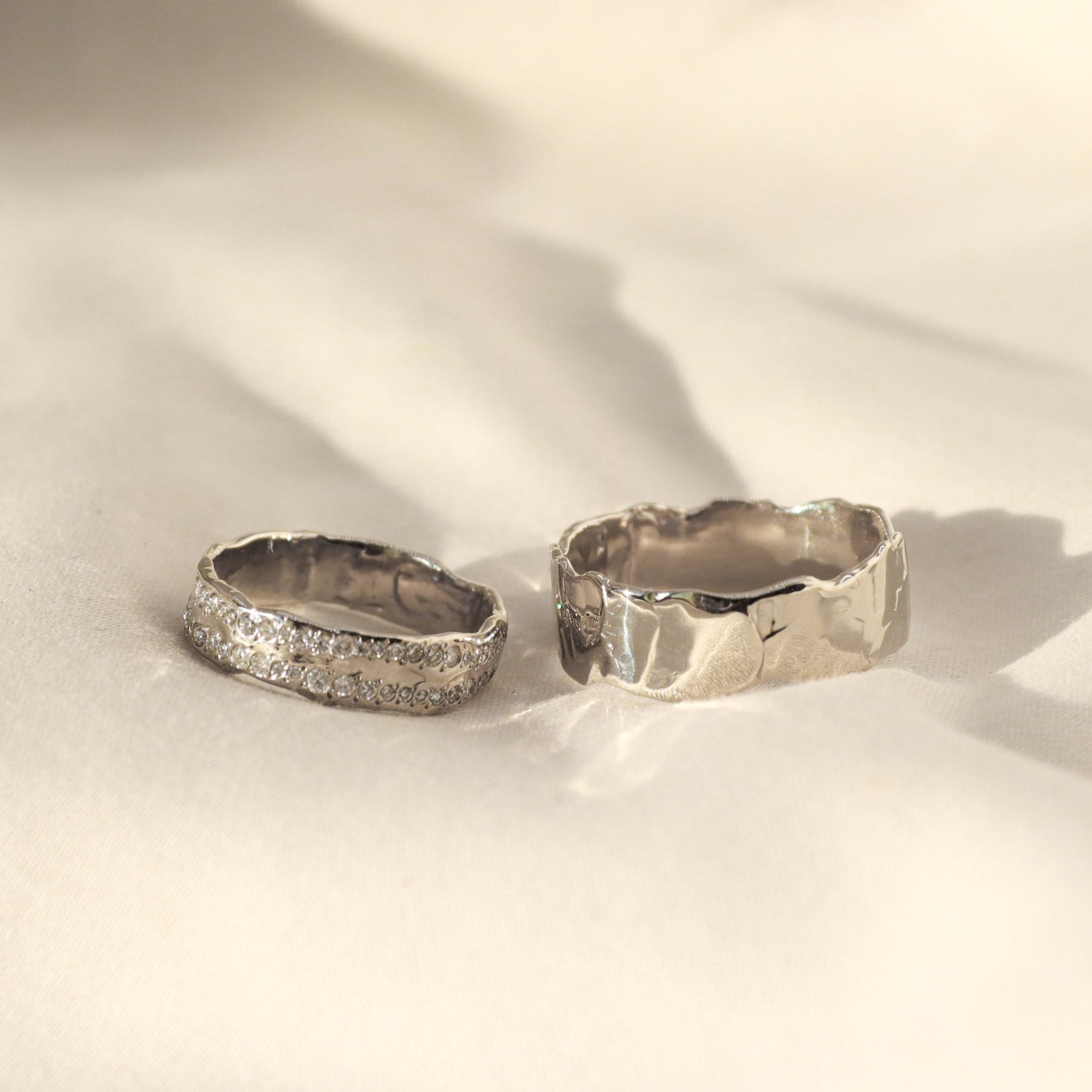 white gold matching wedding bands, one is plain and the other has two rows of diamonds