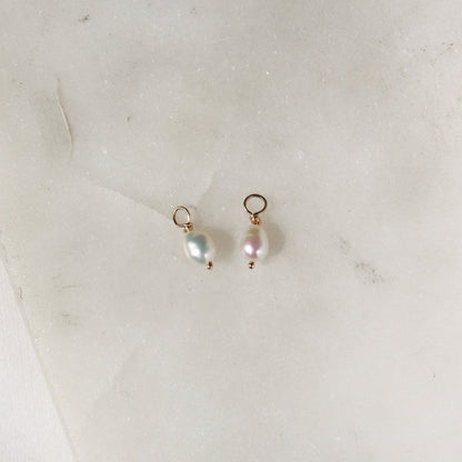 Tiny pearl hoop charm on white background