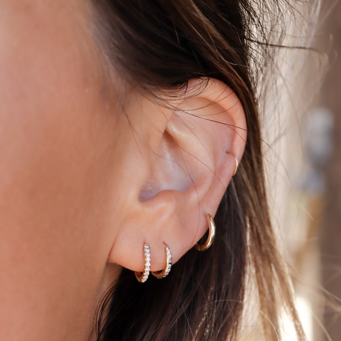 a variety of gold diamond hoops in an ear stack