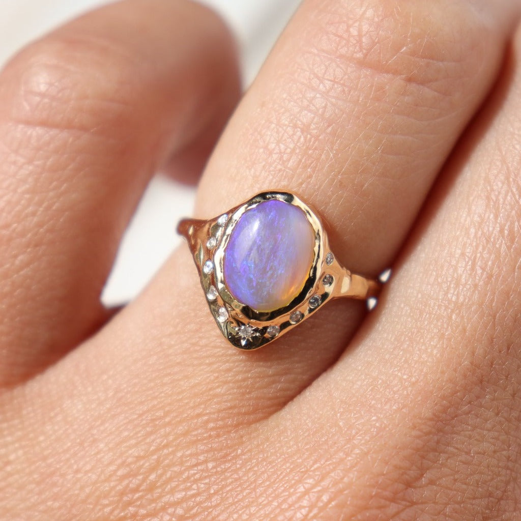 close up of a purple pipe opal ring worn on the ring finger