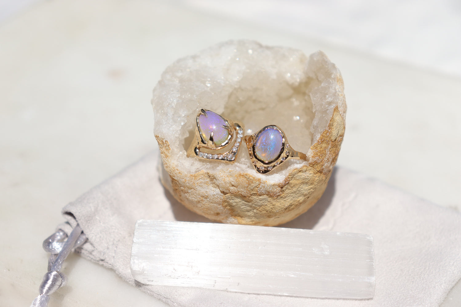 two pipe opal rings sitting inside a crystal on a white surface