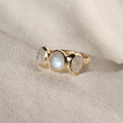 Three rose cut moonstones are bezel set in 14k gold across the front of an organic band.