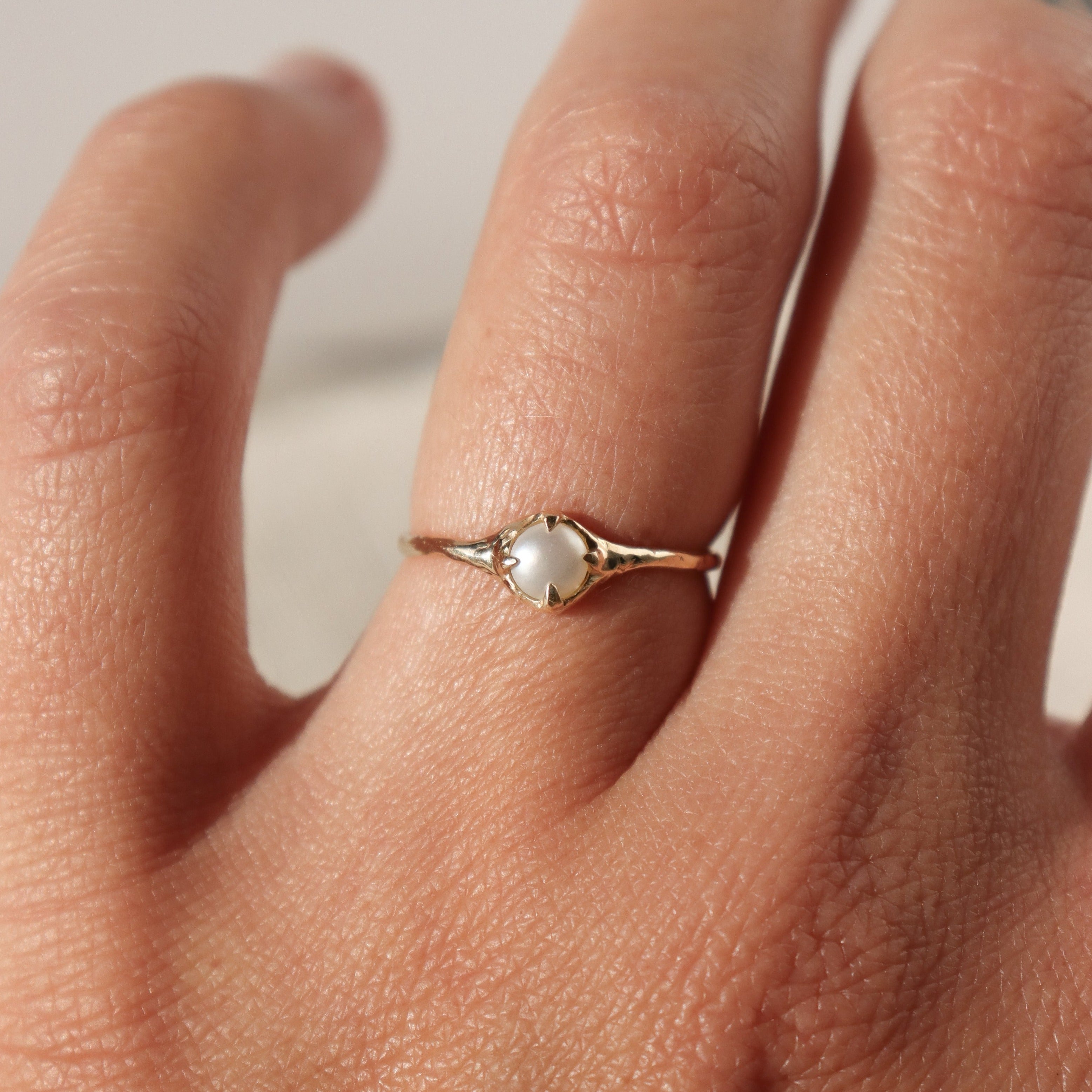 14k gold pearl stacking ring worn on the ring finger