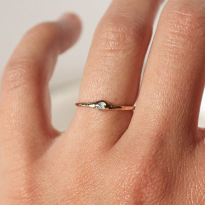a tiny opal ring worn on the ring finger