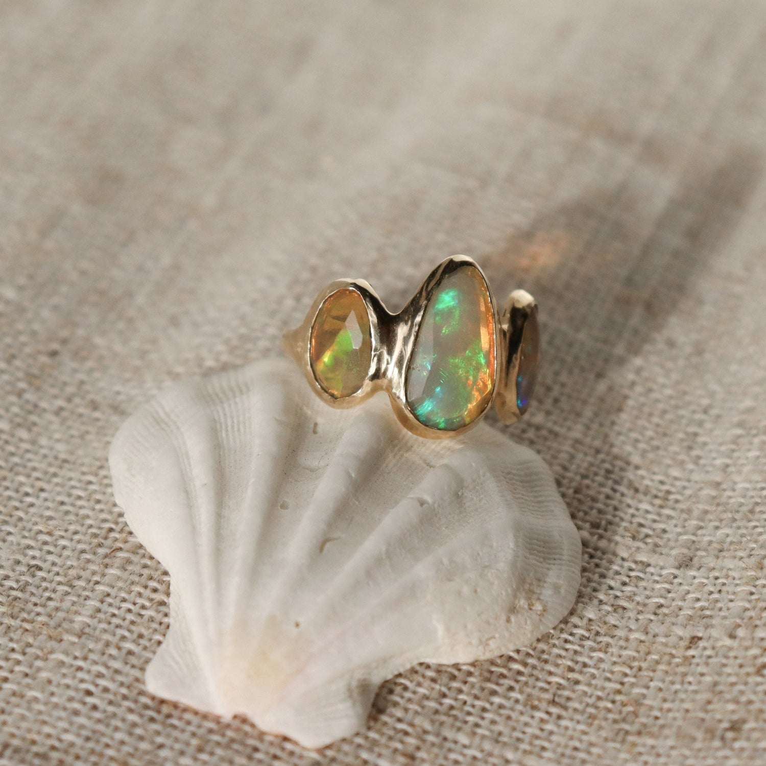 Three opals are bezel set on an organically handcrafted 14k gold band.