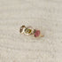 Watermelon tourmaline gemstones are bezel set along the front of a 14k gold band.