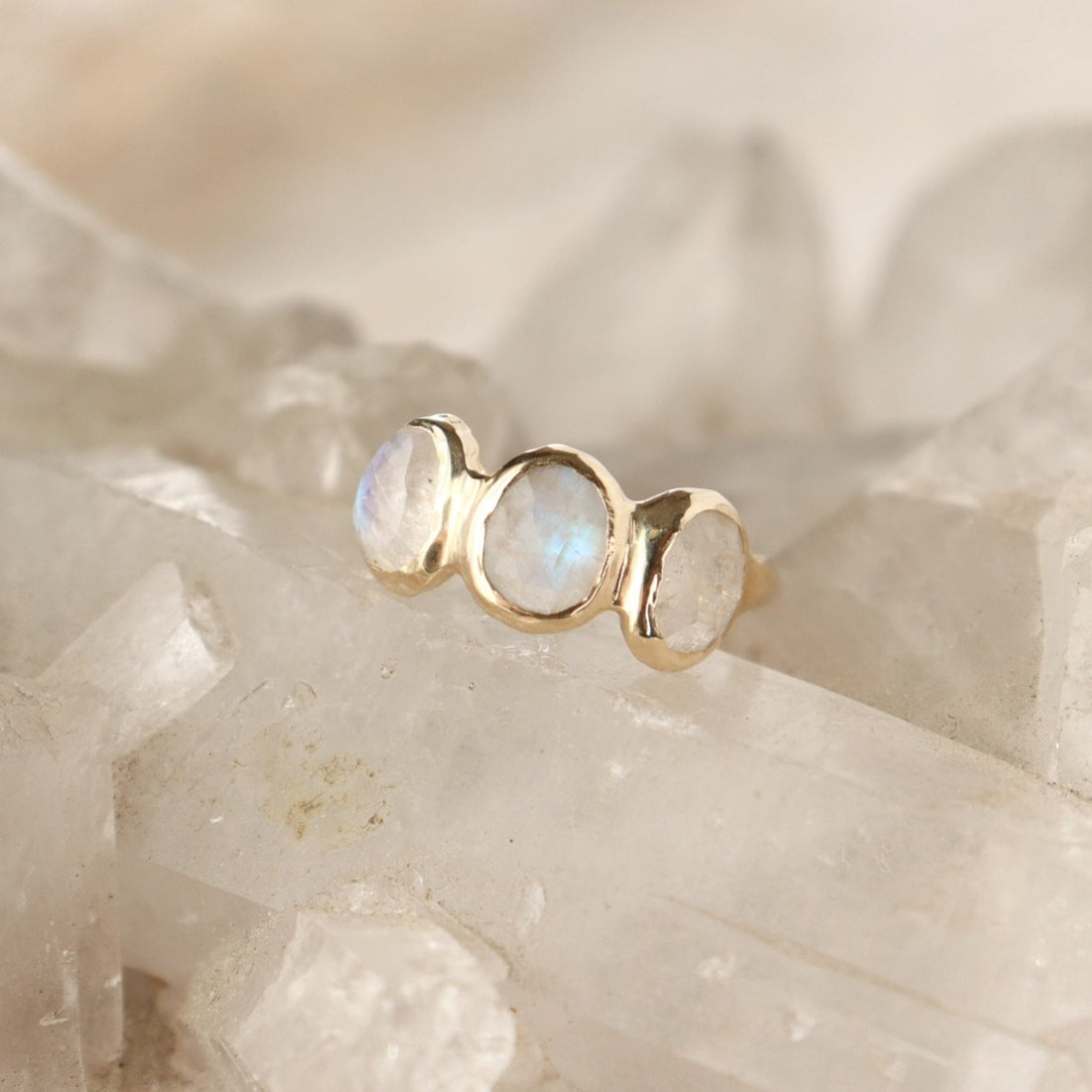 Three rose cut moonstones are bezel set in 14k gold across the front of an organic band.