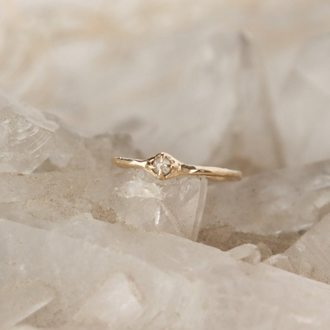 Tiny rose cut icy diamond is set with prongs on a narrow 14k gold band.