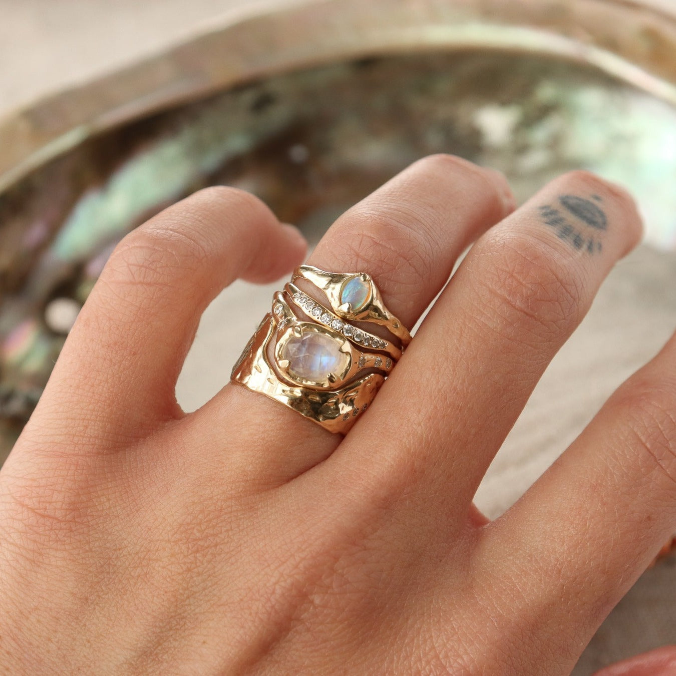 Stack of unique 14k gold gemstone rings.