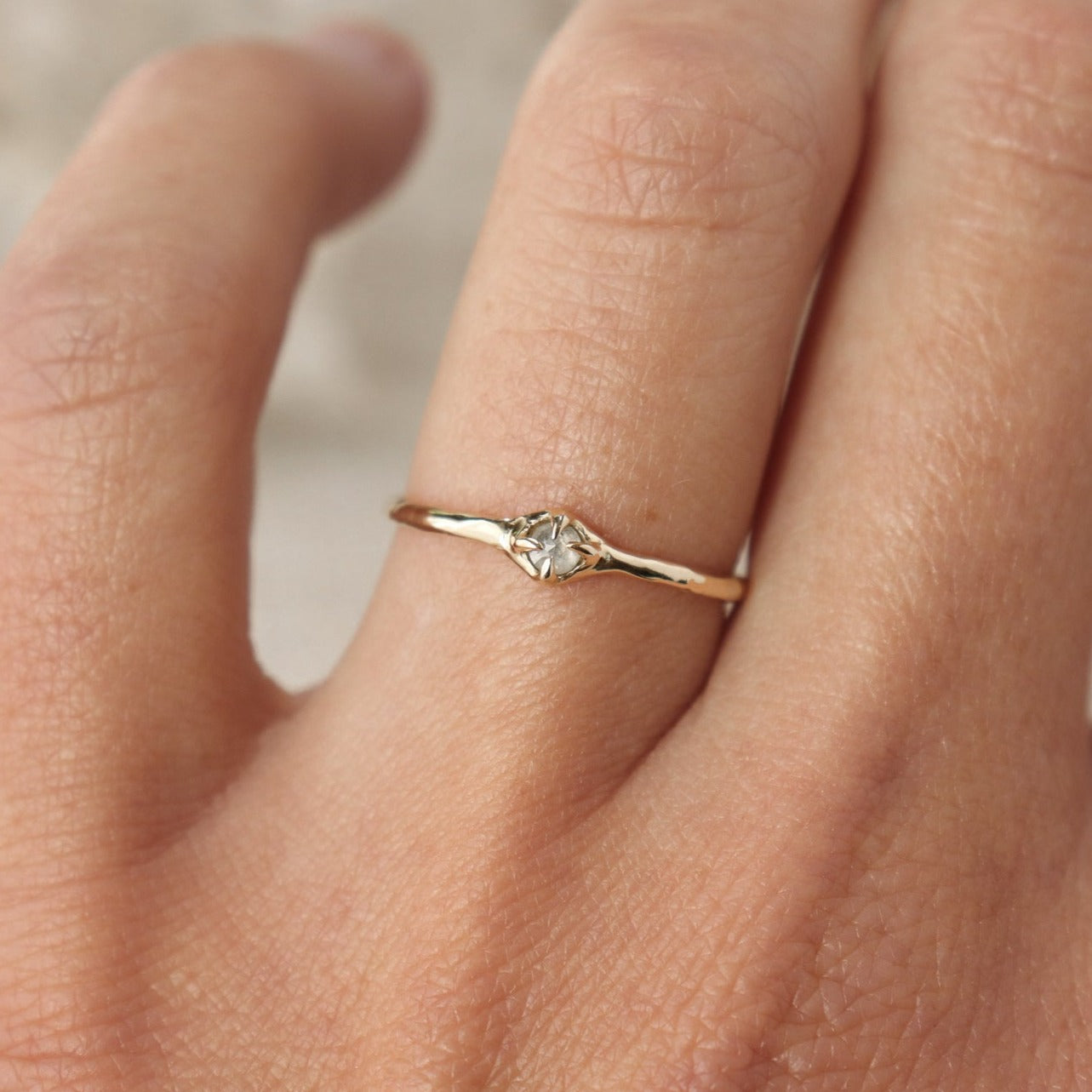 Tiny rose cut icy diamond is set with prongs on a narrow 14k gold band.