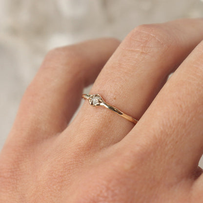 Tiny rose cut icy diamond is set with prongs on a narrow 14k gold band.