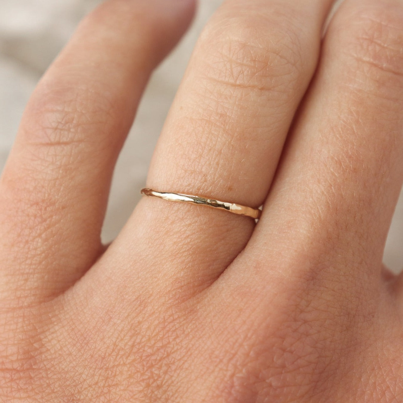 An ultra narrow 14k gold organic stacking band.