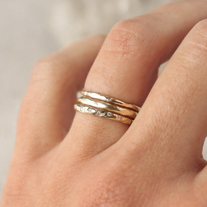 Three 14k gold stacking bands worn on the ring  finger.