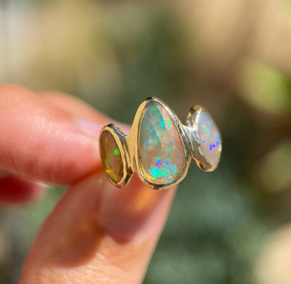 Three opals are bezel set on an organically handcrafted 14k gold band.
