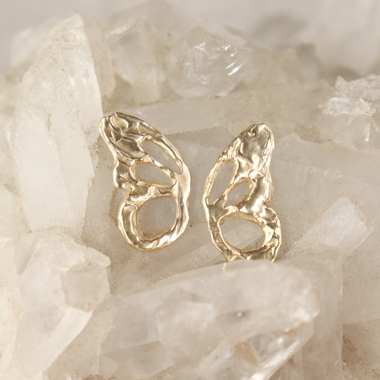 A pair of 14k gold butterfly wing charms, each charm is one part of the wing.