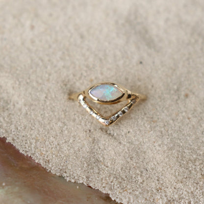 Horizontal marquise opal on a slender band with an organic diamond-set V accent, creating a stunning and unique ring design.